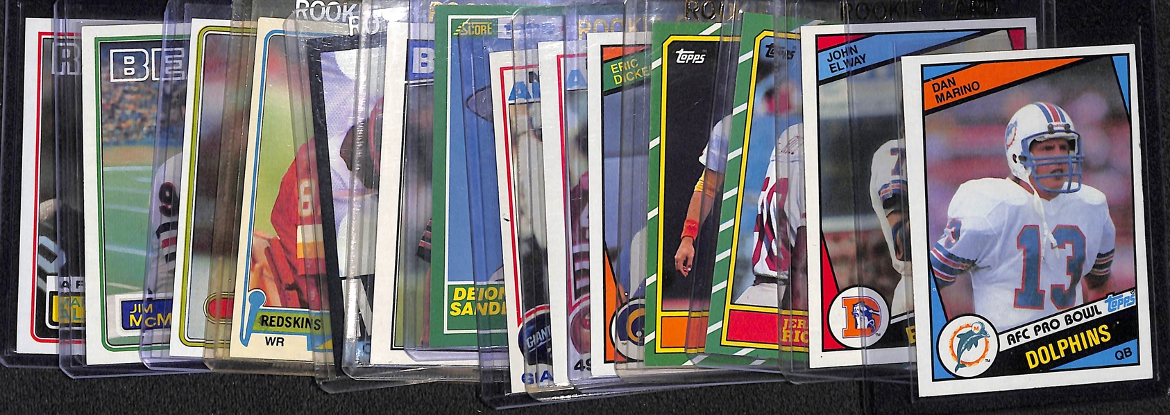 Lot of (14) 1980s Football Star Rookie Cards Feat. Marino, Elway, Rice, Taylor, Dickerson, D. Sanders, and More